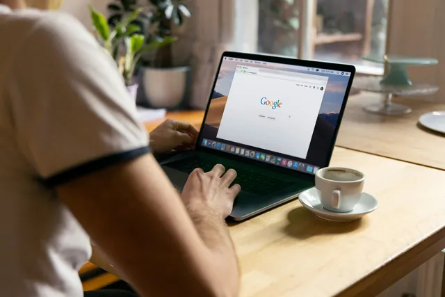A person running a search on a laptop in a cafe