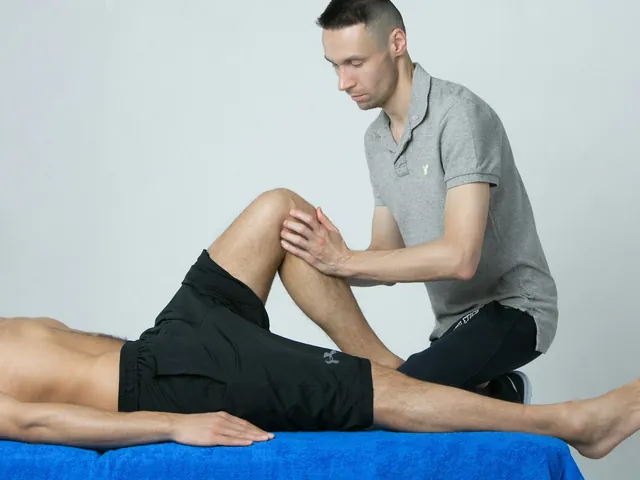 A physical therapist working on a patient's knee