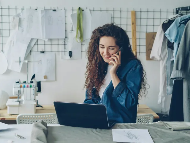 A shop owner taking a call at her workbench
